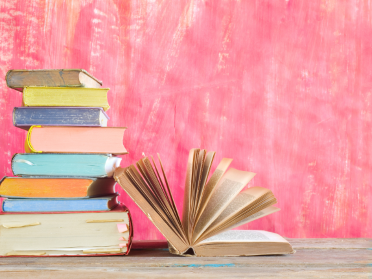 Stacked books against a pink background