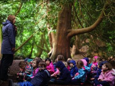 Nature Classroom, in woods, students sitting and teacher standing