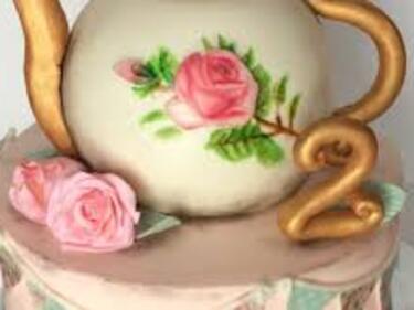 Beautiful tea kettle white with pink rose and gold trim on a light pink cake with 2 pink roses beside the kettle