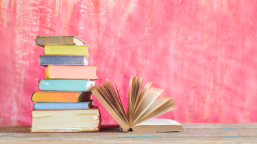 Stacked books against a pink background