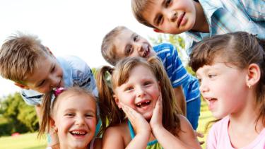 variety of small kids huddled together smiling