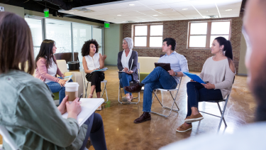 parents sitting on chairs in a circle in a classroom having a PAC meeting