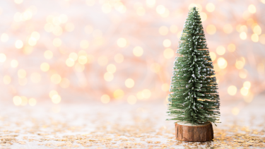 Small toy christmas tree with sparkles in background