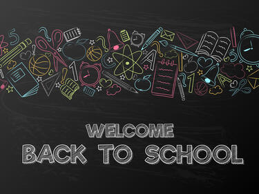 Welcome Back to School on black background with banner of florescent school supplies, assorted