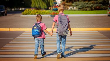 Young Boys holding hands walking to school