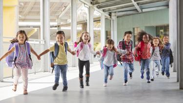 Elementary School kids run holding hands
