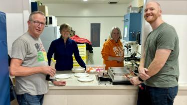 Margaret Stenersen Community Breakfast Program 2024 4 Adults standing at a counter who support the community breakfast program at the school