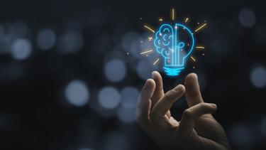 iStock - lightbulb brain graphic Hand holding drawing virtual lightbulb with brain on bokeh background for creative and smart thinking idea concept