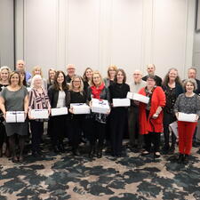 Group of employees holding white boxes, celebrating years of service