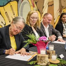 Four leaders signing the new enhancement agreement