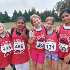Elementary students posing in school field after track & field practice