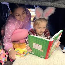 Girls Reading Under a desk