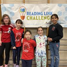 Students who participated in the Reading Link Challenge in front of sign