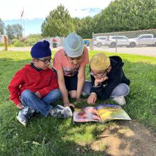 Students Reading a Book outside on the grass
